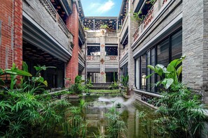 A courtyard with a water feature, brick walls, and greenery.