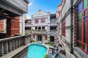 A courtyard with a swimming pool, brick buildings, and a traditional architectural style.