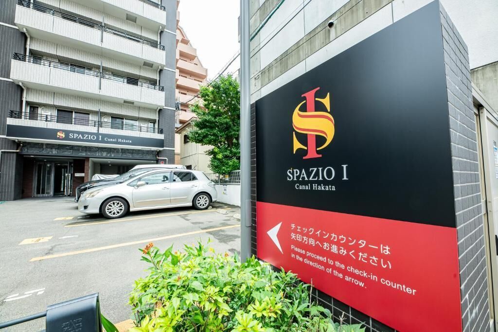 Ein Gebäude mit einem Schild für 'SpaZIO I Canal Hakata' und einem Pfeil, der nach links zeigt.
