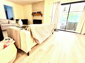 A living room with a sofa, a coffee table, a fireplace, and a sliding glass door to the outside. - Spacious 5BR Pet-Friendly Retreat on a 14,000 Sq Ft Lot (Stockton)