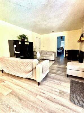 A living room with a sofa, a television, a coffee table, and a fireplace. - Spacious 5BR Pet-Friendly Retreat on a 14,000 Sq Ft Lot (Stockton)