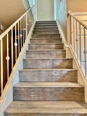 A staircase with wooden steps and white railings. - Spacious 5BR Pet-Friendly Retreat on a 14,000 Sq Ft Lot (Stockton)