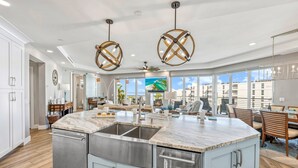 A modern kitchen with a large island, stainless steel appliances, and a view of the ocean. - NEW! Gulf View Suite | Gulf Views, Shared Pool, Exclusive Beach Access (Siesta Key)