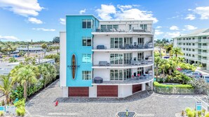 A multi-story hotel with balconies, a blue accent wall, and a view of the surrounding area. - NEW! Gulf View Suite | Gulf Views, Shared Pool, Exclusive Beach Access (Siesta Key)