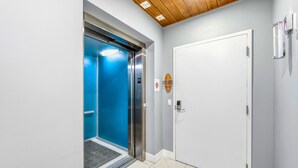 An elevator with a blue interior, a white door, and a wooden ceiling. - NEW! Gulf View Penthouse | Gulf Views, Hot Tub, Top-Floor Balcony (Sarasota)