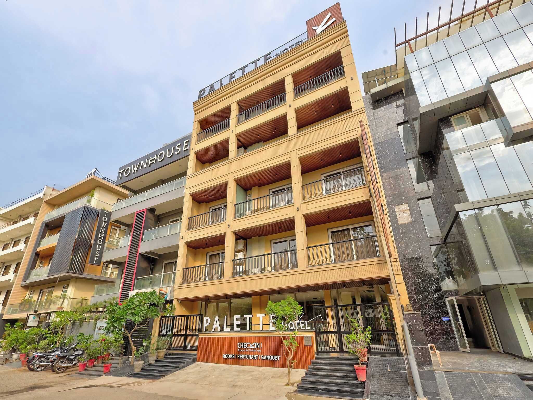 A multi-story hotel with balconies, a check-in counter, and a sign for a restaurant and banquet.