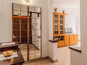 A room with a wooden cabinet, a television, and a dining table with a bowl. - Casa Iolanda by Interhome (Carlazzo)