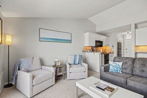 A living room with two sofas, a coffee table, and a kitchen in the background. - 🏖️ Top-Floor Bay-View 1BR @ The Shores | Grand Traverse Resort | Sleeps 6 (Williamsburg)
