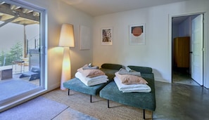 A modern room with a sofa, a lamp, and artwork on the wall. - Éthéra 19: Forest Chalet, Hot Tub & Deck (Petite-Rivière-Saint-François)