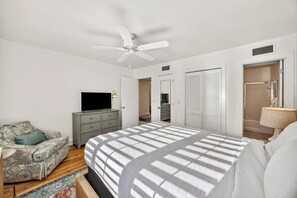 A bedroom with a bed, a TV, a ceiling fan, a wardrobe, and a bathroom. - Oyster Catcher - 4 bedroom home! Seabrook Island Gem, close to beach! (Seabrook Island)