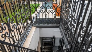 A black wrought iron staircase with intricate designs, leading to an upper level. - Pet Friendly Studio in Fulham, Sleeps 2 (London)