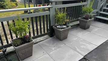 Un balcó amb un cartell de benvinguda, plantes en testos i vistes als voltants.