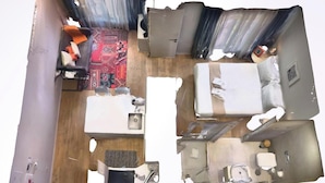 Ein Zimmer mit einem Bett, einem Schreibtisch, einem Sessel, einem kleinen Tisch und einem Teppich.