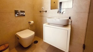 Ein Badezimmer mit Toilette, Waschbecken und Spiegel.