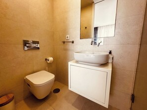 Ein Badezimmer mit Toilette, Waschbecken und Spiegel.