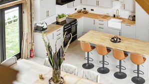 A modern kitchen with white cabinetry, a wooden countertop, and a central island with bar stools. - Barn - Sleeps 10 - Hot Tub - Parking (Reigate)