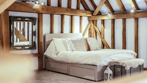 A bedroom with a bed, a mirror, and a chest of drawers. - Barn - Sleeps 10 - Hot Tub - Parking (Reigate)