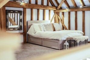 A bedroom with a bed, a mirror, and a chest of drawers. - Barn - Sleeps 10 - Hot Tub - Parking (Reigate)