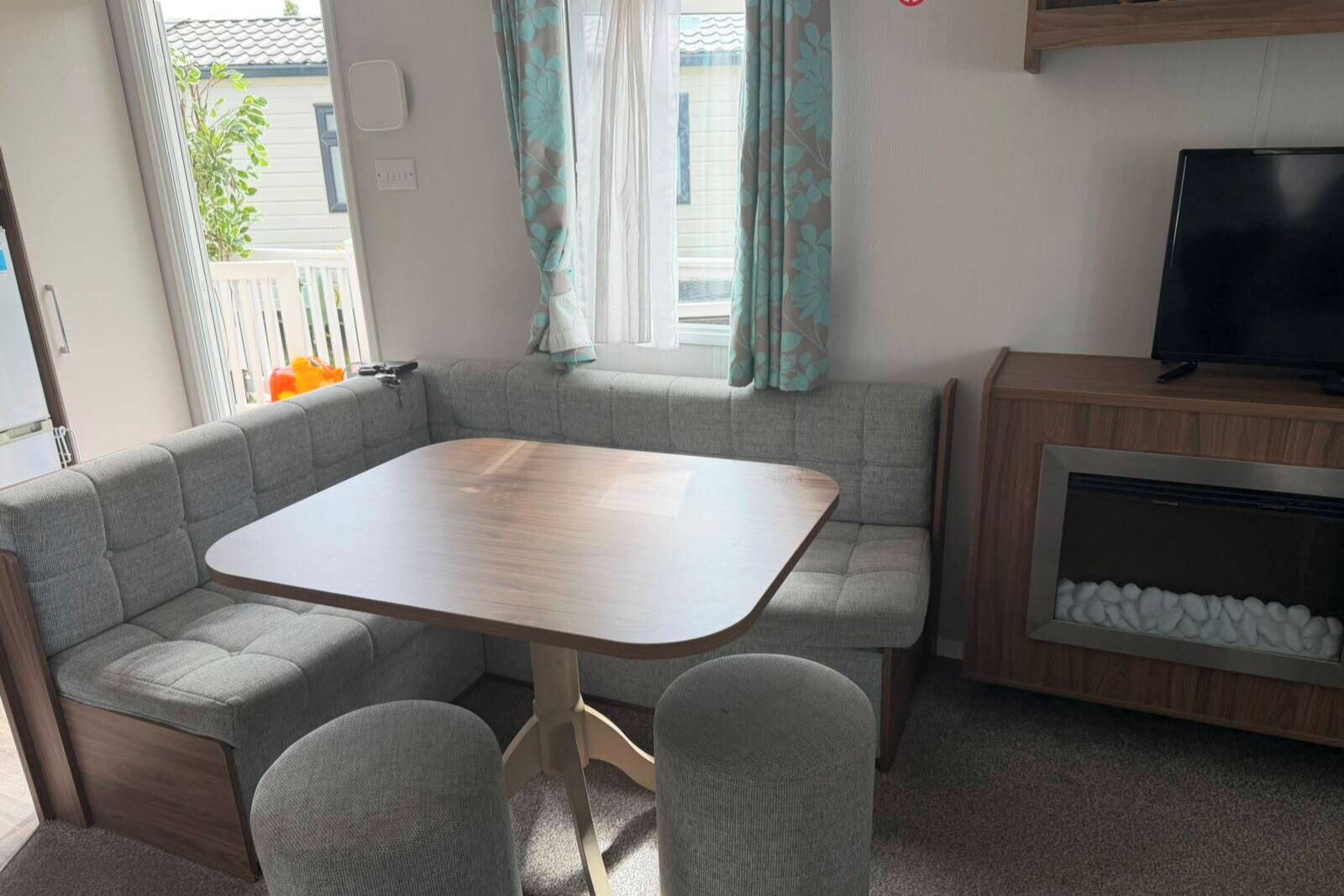 A compact living space with a sofa, a table, and a television.