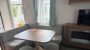 Un espacio habitable compacto con sofá, mesa y televisor.
