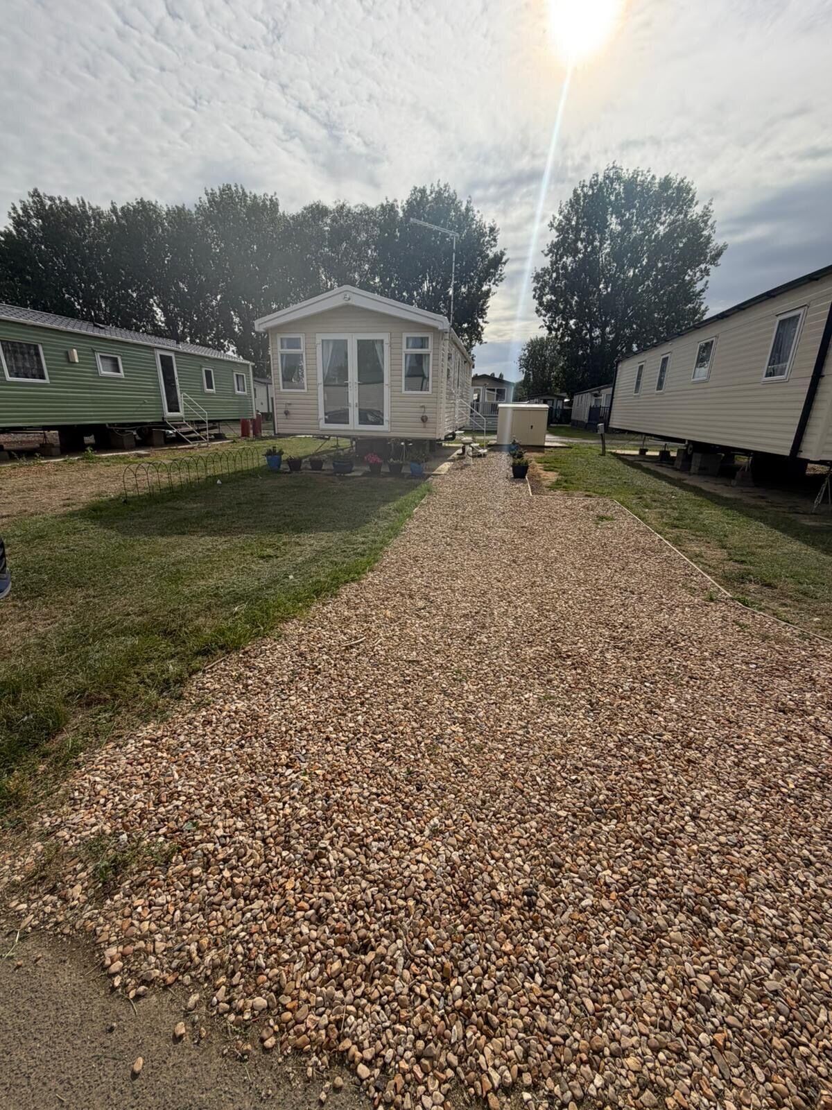 A row of mobile homes with gravel paths between them.