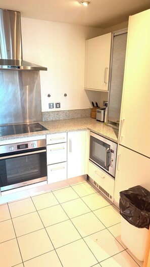 A kitchen with a stainless steel range hood, a built-in oven, a microwave, and a refrigerator. - Luxury Central London Apartment Paddington (London)