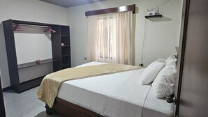 A bedroom with a bed, a wardrobe, a desk, and a window with curtains. - Divina Naturaleza (Fortuna)