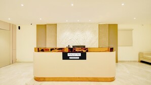 Una reception con una insegna che recita 'PALETTE Company-Serviced' in un'area hall moderna e ben illuminata.