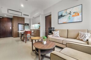 Ein modernes Wohnzimmer mit Sofa, Couchtisch und Essbereich.