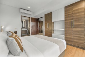 Ein modernes Schlafzimmer mit einem großen Bett, einem Holzschrank und eingebauten Regalen.