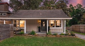 Een gelijkvloers huis met een veranda, een zwarte voordeur en het nummer '2106' aan de rechterkant.