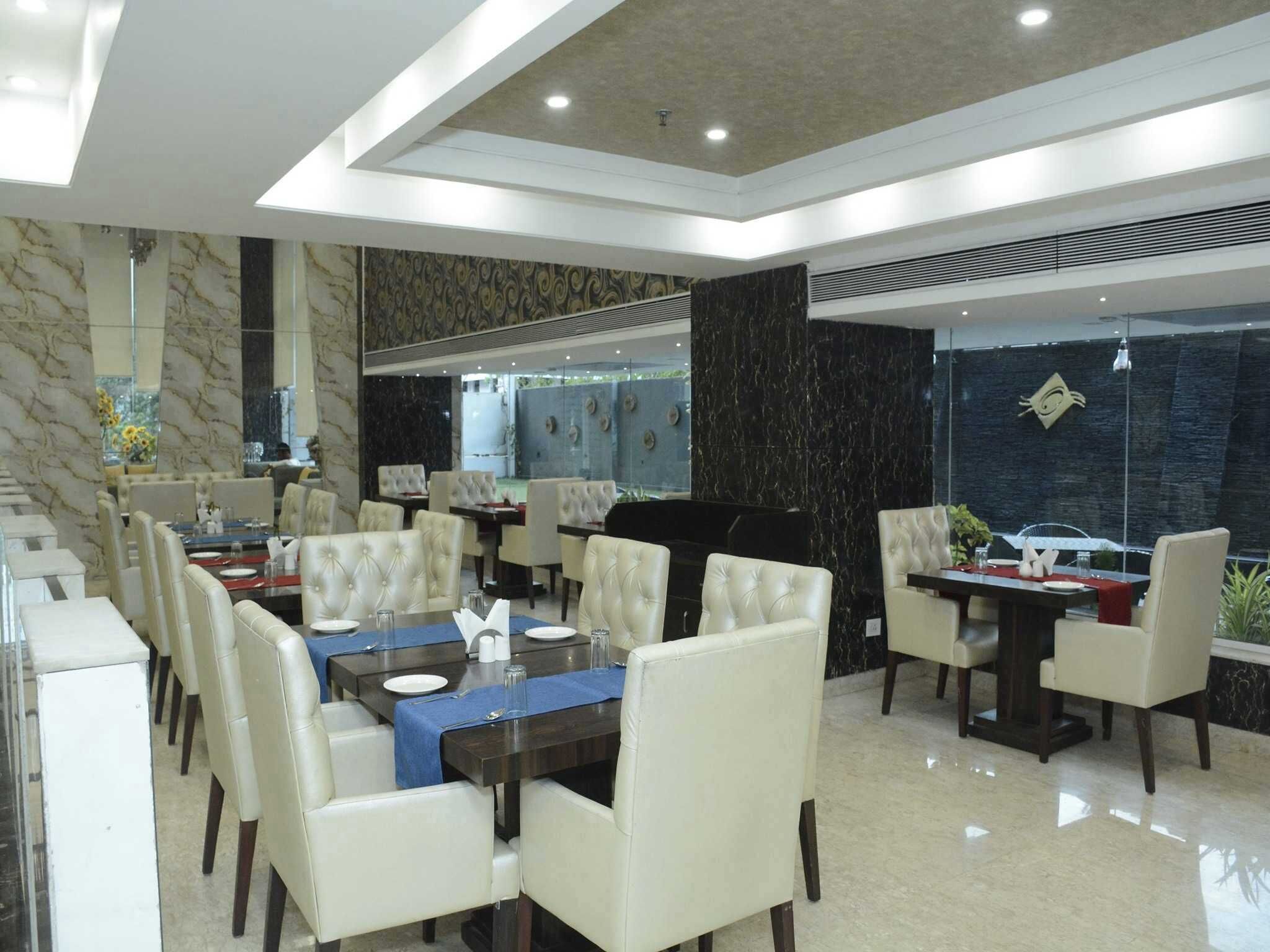 A modern dining area with marble walls, leather chairs, and a central dining table.