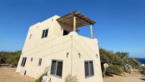 A modern building with a flat roof, multiple windows, and a sandy ground. - Casa El Viento: Modern 3-Bedroom Desert & Sea Retreat in El Sargento (El Sargento)