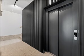 A modern elevator with a metallic finish and a control panel on the right side. - Zamojska Skyline View Apartment (Lublin)