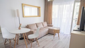Ein modernes Wohnzimmer mit einem Ecksofa, einem runden Couchtisch und einem Fernseher-Möbel.