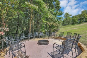 An outdoor seating area with metal chairs and a circular fire pit. - NEW! Jenny Lynn Lodge (Logan)