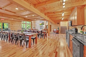 A spacious wooden interior with a dining area, kitchen, and a fireplace. - NEW! Jenny Lynn Lodge (Logan)