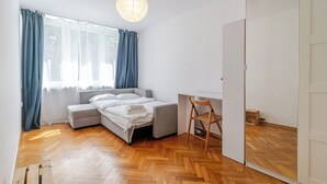 Quarto com uma cama, uma escrivaninha e uma cadeira.