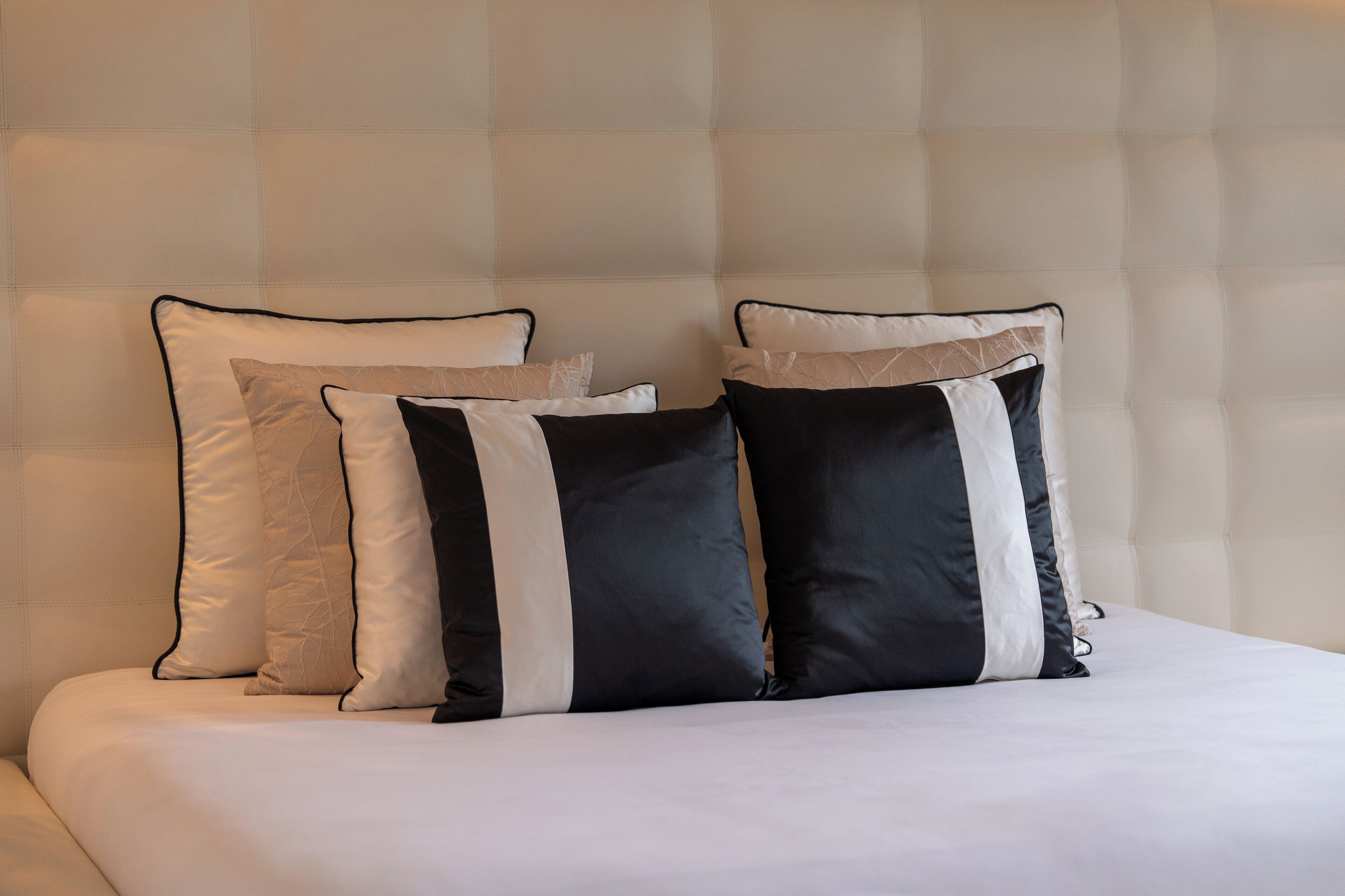 A bed with a headboard and three pillows.