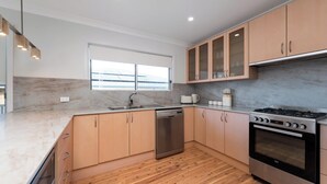 Una cocina moderna con lavavajillas, estufa y armarios de madera.