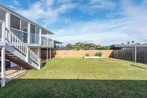 A residential backyard with a wooden deck, a fenced area, and a grassy lawn. - Mollymere | Ocean View Coastal Retreat (Mollymook Beach)