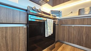 Una cucina moderna con forno integrato, microonde e tostapane.