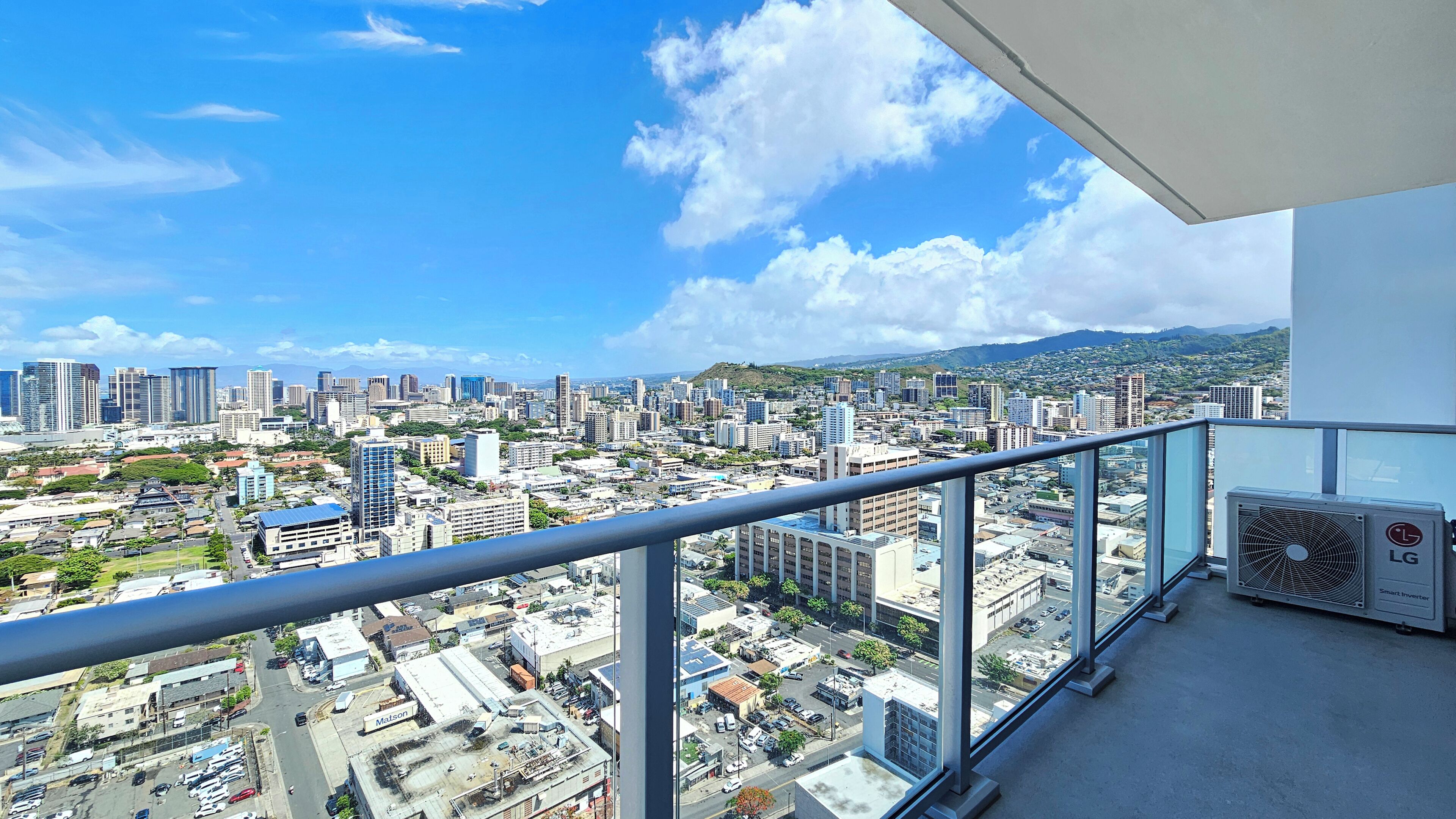 Ein Balkon mit Blick auf die Stadt, inklusive Gebäude und einer entfernten Bergkette.