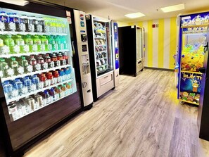 Ein Flur mit Automaten an beiden Seiten, ein Spielbereich im Bärenstil und eine Tür mit gestreifter gelb-weißer Wand.