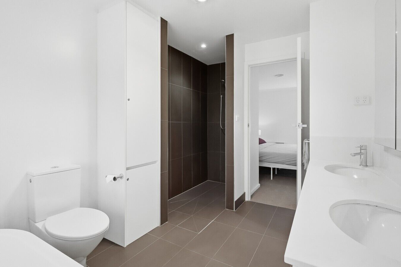 Une salle de bain moderne équipée de toilettes, d’une douche et d’un lavabo.