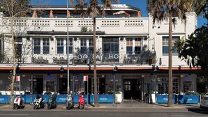 A hotel with a modern facade, multiple balconies, and a parking area with scooters. - Spacious Waterfront Loft at Woolloomooloo Wharf (Woolloomooloo)