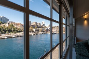 A view from a window with a cityscape, including buildings and a body of water. - Spacious Waterfront Loft at Woolloomooloo Wharf (Woolloomooloo)
