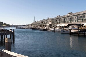 A marina with docked boats, a row of buildings with balconies, and a clear sky. - Spacious Waterfront Loft at Woolloomooloo Wharf (Woolloomooloo)