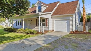 A single-story house with a front porch, a garage, and a well-maintained lawn.