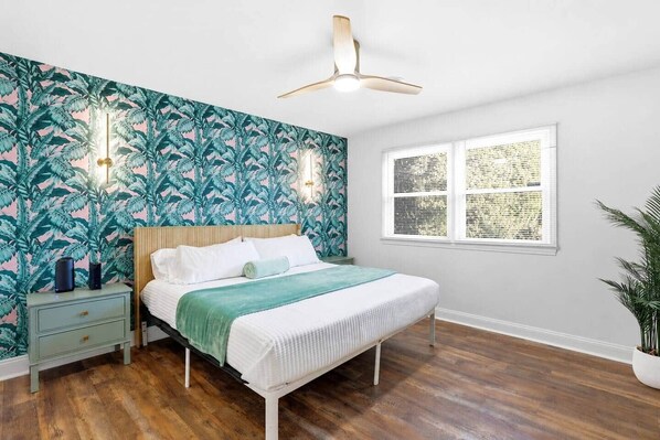 A bedroom with a bed, nightstand, wall-mounted lights, ceiling fan, and a window with blinds. - The Salty Palm-Pool-Hot Tub-Firepit-Gameroom (Silver Lake)